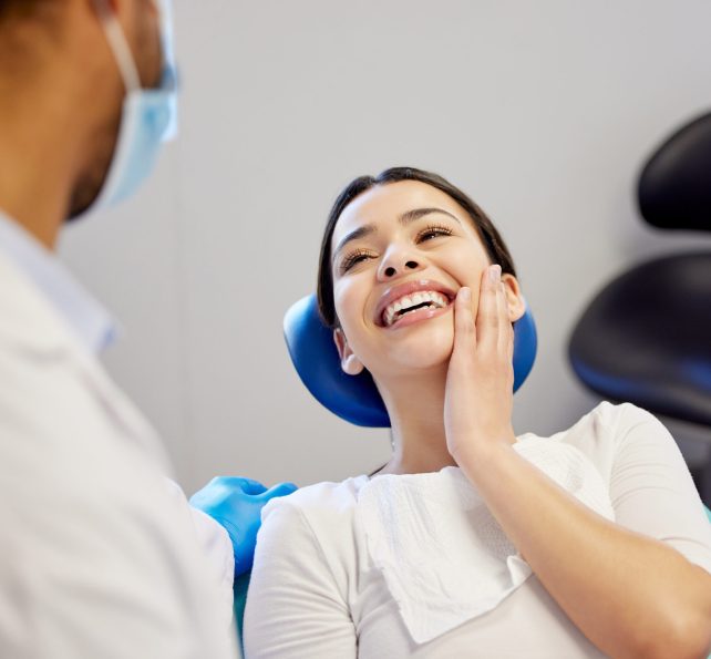 Woman, dentist and happy for dental surgery in clinic with support for teeth removal and treatment with doctor. Female patient, satisfied and smile on consultation for canal procedure and oral care.